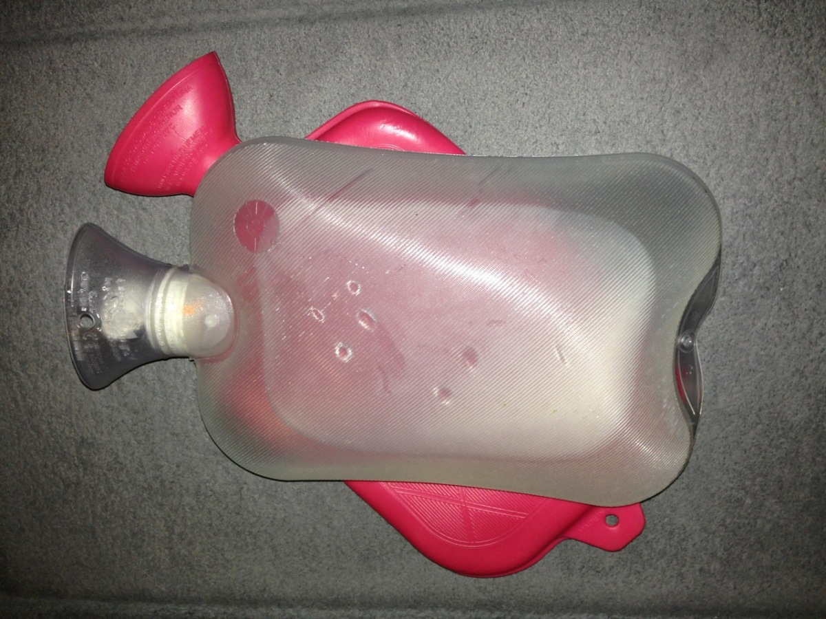 Hot water bottles in clear plastic and red rubber