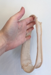 woman's hand holding tube of nylon cut from pantyhose