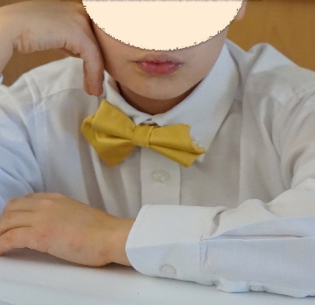young child in white oxford, yellow bow tie, and top hat